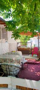 a table and chairs on a patio under a tree at каравана ТРОПИК-ЕКЗОТИК А 17 in Sozopol
