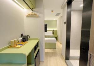 a room with a kitchen with a bed in the background at Urbanwood Hung Hom in Hong Kong