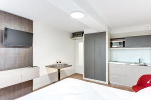 Una cocina con gabinetes blancos y una silla roja. en Le Nénuphar - Parking, Hyper-Centre, 500m Gare, en Cholet 16 fotos más