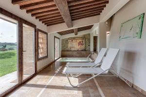 Habitación con silla y piscina en Villanovia Country House, en Volterra