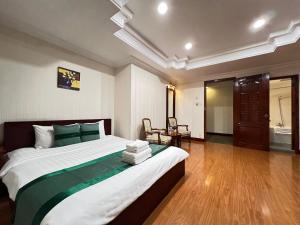a bedroom with a large bed and a bathroom at Riverside Hotel Saigon in Ho Chi Minh City