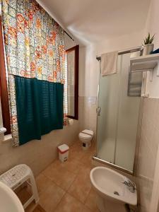 uma casa de banho com uma cortina de chuveiro e um WC em A Due Passi dal Centro em Favignana