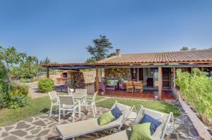 a patio with chairs and a table and a house at VILLA MARIA - CAPO D'ORSO - HOME and MORE in Palau