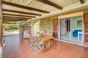 a dining room with a table and chairs on a patio at VILLA MARIA - CAPO D'ORSO - HOME and MORE in Palau
