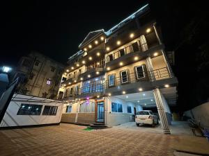 グワーハーティーにあるTHE VISTA RESIDENCYの夜間の車両が停まる建物
