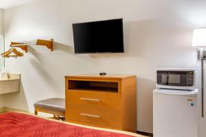 Zimmer mit einem TV und einer Kommode mit einer Mikrowelle. in der Unterkunft Econo Lodge in Creedmoor