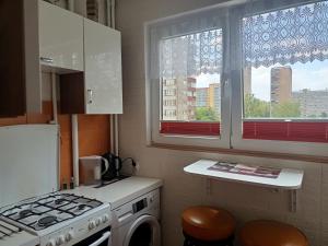 a kitchen with a stove top oven next to a window at Atrakcyjne Matejki in Świnoujście