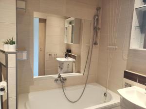 a bathroom with a shower and a tub and a sink at Atrakcyjne Matejki in Świnoujście +6 photos