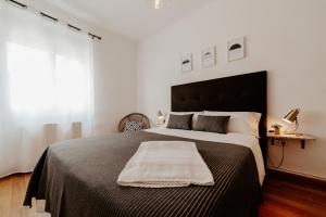 een slaapkamer met een groot bed met een deken erop bij Apartamento Juzgados in Logroño