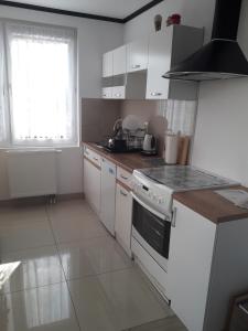 a kitchen with white cabinets and a stove top oven at Całoroczny Apartament u Grzegorza in Lidzbark
