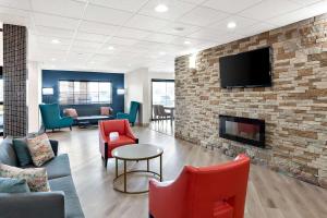 a living room with a fireplace and a tv on a brick wall at Comfort Suites Columbus in Columbus