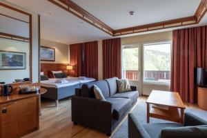 une chambre d'hôtel avec un canapé et un lit dans l'établissement Scandic Rukahovi, à Ruka