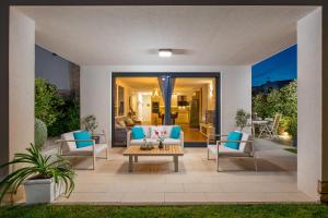 un patio con sillas azules y una mesa en Luxury apartment Hyperion with private pool and garden, en Murter