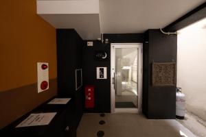 a black and white room with a door to a hallway at Hotel SERA LUNA -ホテル セラルナ- in Naha