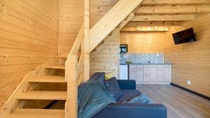 uma sala de estar com uma escada numa casa de madeira em Domki Elmak Mikoszewo PIAMOLA em Mikoszewo