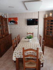a dining room with a table and chairs and a television at Casa Antonio in Águilas +4 photos