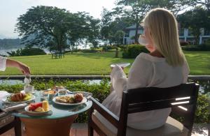 琅勃拉邦的住宿－The Grand Luang Prabang, Affiliated by Meliá，坐在餐桌上吃一盘食物的女人