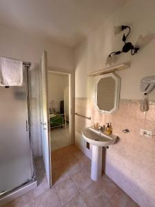 a bathroom with a sink and a shower with a mirror at A Due Passi dal Centro in Favignana