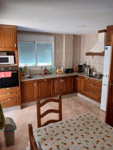 a kitchen with wooden cabinets and a table in it at Casa Antonio in Águilas