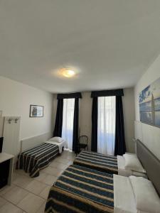 una camera d'albergo con due letti e un divano di Hotel Alessander a Milano