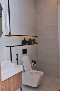 a bathroom with a white toilet and a sink at Nuzul R163 - Elegant Apartment in Riyadh