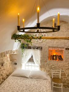 1 dormitorio con 1 cama y chimenea de piedra en Domus Klara, en Turi