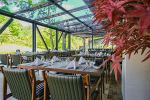 uma sala de jantar com mesas e cadeiras com folhas vermelhas em Vital Thermal Hotel & SPA em Termal