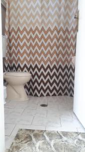 a bathroom with a chevron shower curtain and a toilet at Manolis Studios in Kefalos