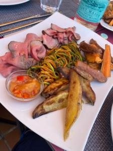une assiette de denrées alimentaires contenant de la viande et des légumes sur une table dans l'établissement Nuramar Resort & Villas, à Cala'n Bosch