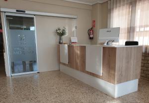 una oficina con recepción y puerta de cristal en Hostal Moreno en Silla