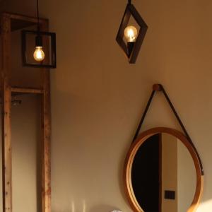 a bathroom with a mirror and lights on the wall at Intha Resort in Ban Khao Lao