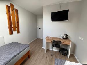a bedroom with a bed and a desk with a television at Milten Domaszewnica in Kolonia Domaszewnica