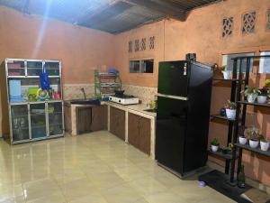 a large kitchen with a large black refrigerator at Zinzi's All-Inclusive Homestay in Sangyang