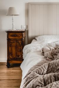 una camera con letto e comodino in legno di Tenuta Agriturismo La Borina a San Bonifacio
