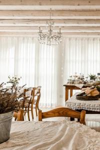 una sala da pranzo con tavolo, sedie e lampadario pendente di Tenuta Agriturismo La Borina a San Bonifacio