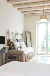 una camera bianca con un letto e una finestra di Tenuta Agriturismo La Borina a San Bonifacio