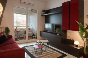 a living room with a red couch and a tv at 56 direttamente sul mare - red tropical in Diano Marina