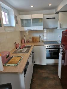 a kitchen with white cabinets and a black stove at Im Herzen des Kraichgaus 2 in Östringen