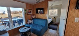 a living room with a blue chair and a bedroom at Hagi 2 Road 62 nr 1 in Hagi