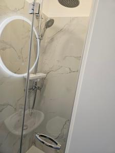 La salle de bains est pourvue d'une douche avec un miroir rond. dans l'établissement Kosovic Family House, à Medulin