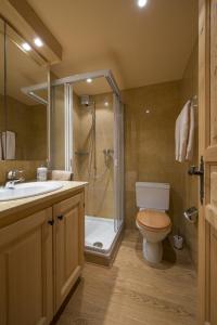 y baño con ducha, aseo y lavamanos. en Apartment Beaumont en Verbier