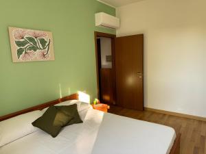 una camera con un letto bianco e una porta marrone di SerendipityComo Guest House a Como