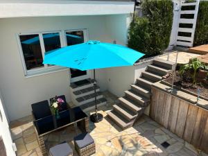 a blue umbrella in front of a house with stairs at City Chillout Heidelberg, Apartment mit Sauna & Pool in Heidelberg