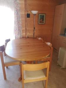 a wooden table with chairs and a lamp in a room at Chalet Blockhaus auf Camping - b48513 in Oberwil