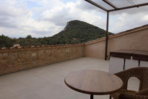 balcón con mesa y vistas a la montaña en Finca Sa Bastida Luxury Retreat & Spa Adults Only, en Sant Joan