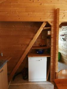 a small kitchen in a log cabin with a refrigerator at Chalet Blockhaus auf Camping - b48513 in Oberwil
