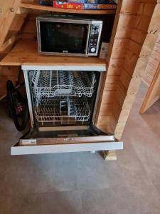 a dishwasher with a microwave on top of it at Chalet Blockhaus auf Camping - b48513 in Oberwil