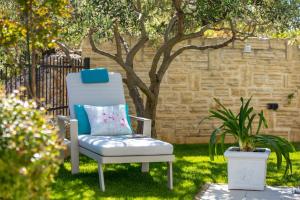 una silla azul en un patio con una planta en Luxury apartment Hyperion with private pool and garden, en Murter