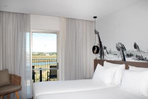 a hotel room with a bed and a window at AP Cabanas Beach & Nature - Adults Friendly in Cabanas de Tavira
