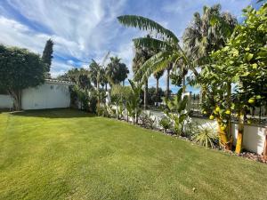a yard with green grass and palm trees at Sunset Villa Arcos in Arcos de la Frontera